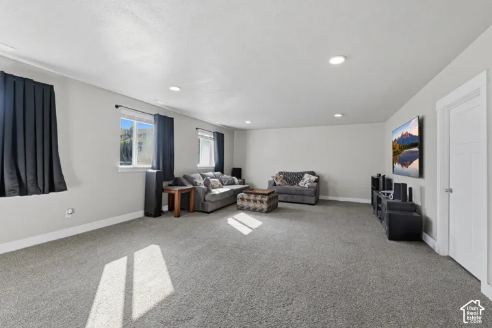 Spacious interior featuring recessed lighting, neutral wall paint, carpeted flooring, and a multi-panel interior door