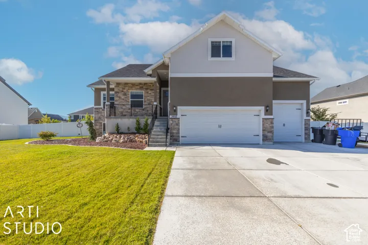 Contemporary exterior with stucco and stone accents, a multi-car garage, and a concrete driveway