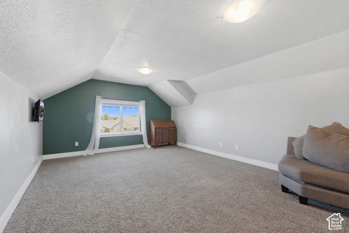 Sloped ceiling, accent wall, dual flush-mount light fixtures, and single-pane window