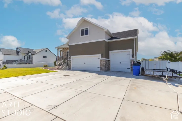 Exterior featuring a two-car garage, stone accents, and a concrete driveway