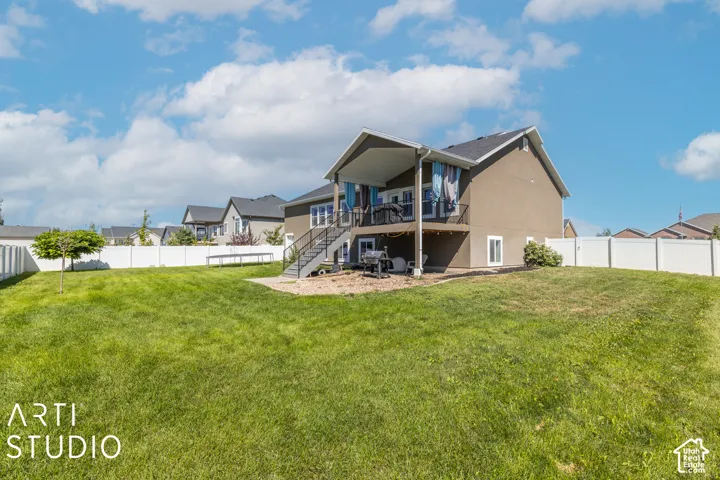 Expansive lawn with a white privacy fence and a two-story stucco exterior