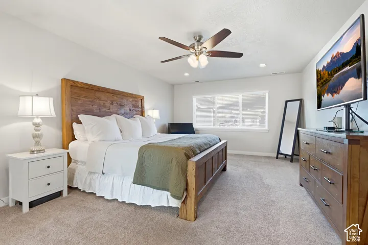 Primary Carpeted bedroom featuring a ceiling fan with integrated lighting, recessed lighting, and a window with blinds