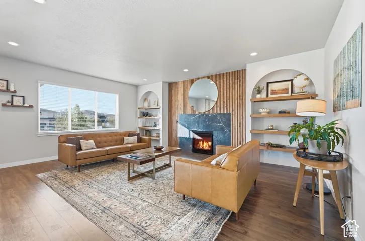 Wood-finish flooring throughout, featuring a modern fireplace with a dark stone surround and wood paneling
