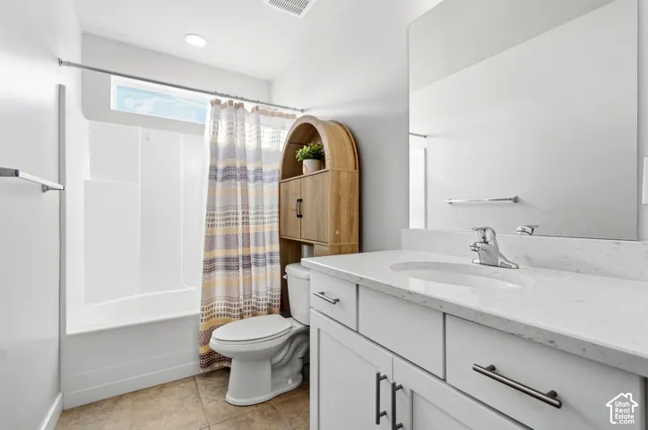 White vanity with a light-colored countertop and undermount sink