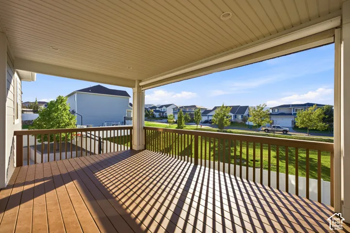 Covered outdoor deck with wood-finish flooring, recessed lighting, and a wood railing