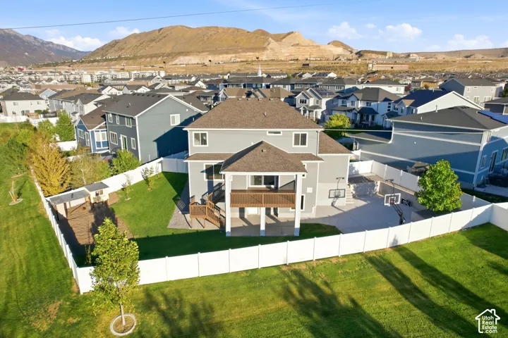 Gray exterior with multiple windows, covered deck, and an expansive lawn