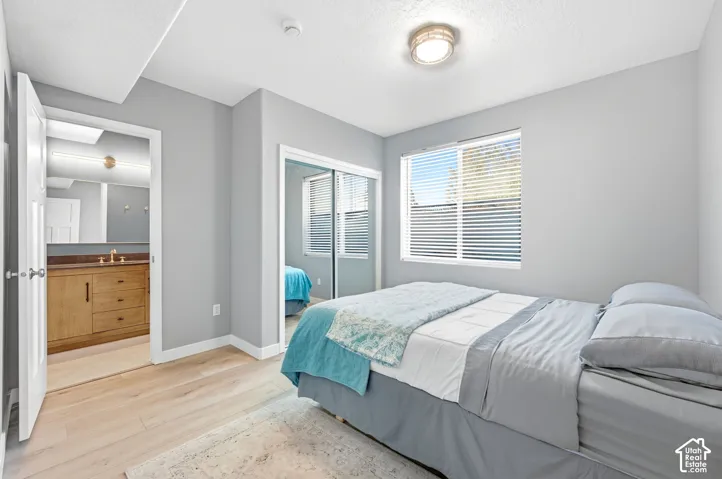 Light wood-finish flooring, white trim, and a window with blinds