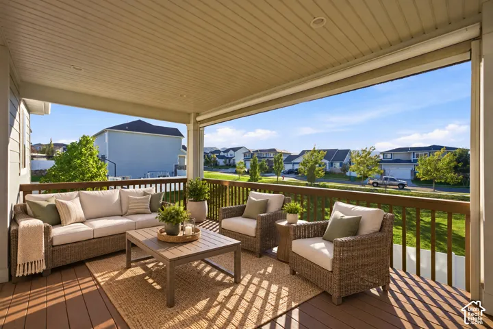 Covered outdoor deck with wood-finish decking, recessed lighting, and a wood railing