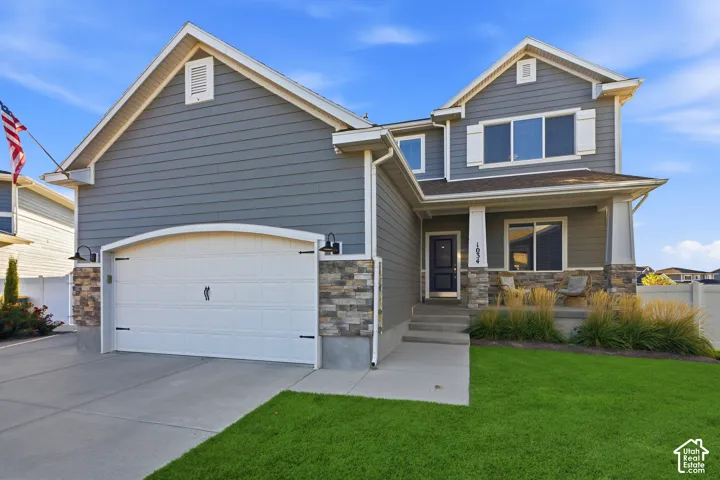 Two-story residence featuring grey siding and stone accents