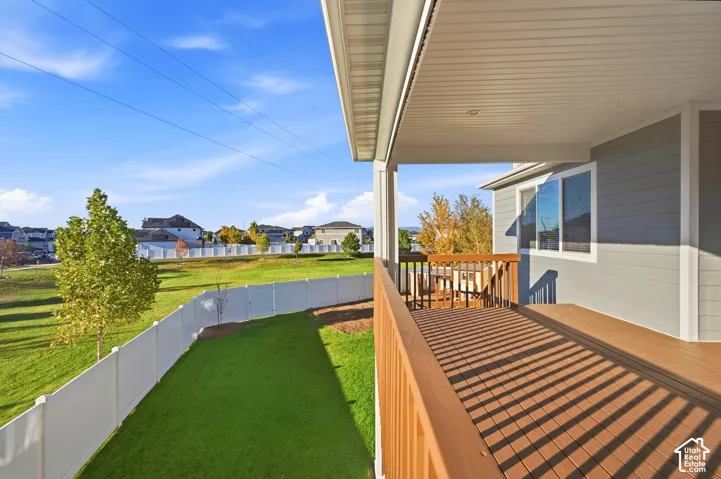 Covered deck with composite wood-finish flooring and wood railing