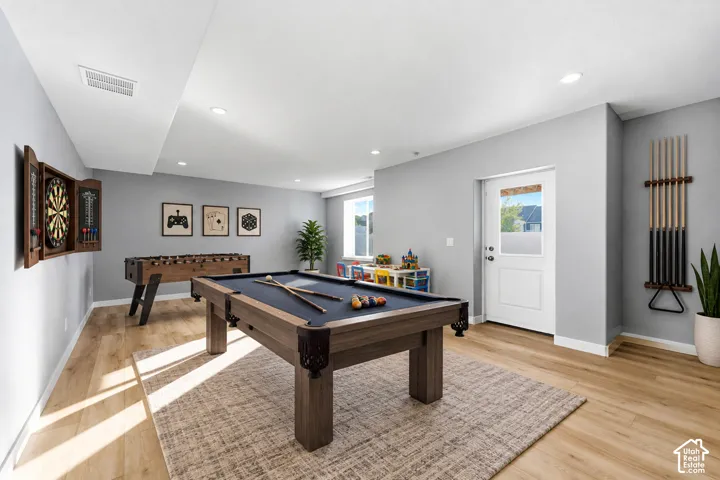 Recessed lighting illuminates wood-finish flooring - could be used as family room or game room