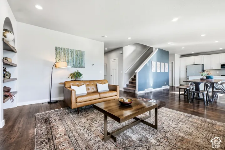 Recessed lighting illuminates wood-finish flooring throughout the open-concept living space