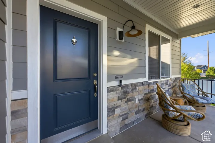 Inviting covered porch with stone veneer accent and siding exterior