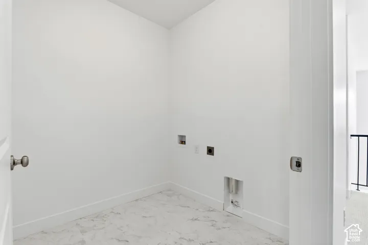 Utility space with light-toned walls and marbled-finish flooring