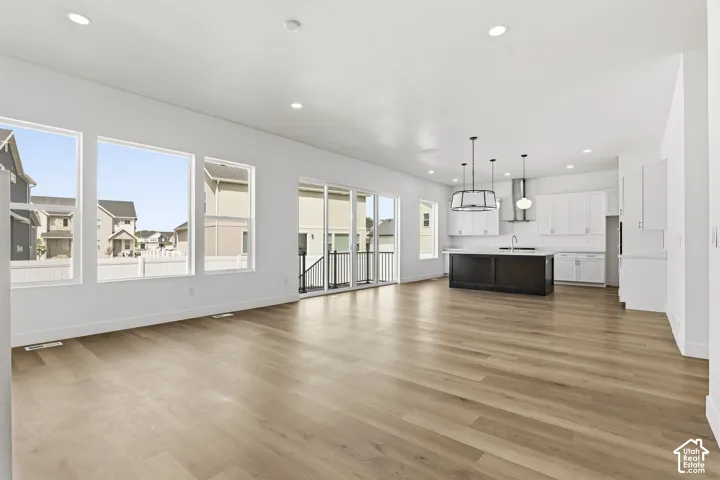 Spacious open-concept living area with light wood-finish flooring