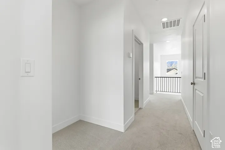 Carpeted hallway with white walls and trim