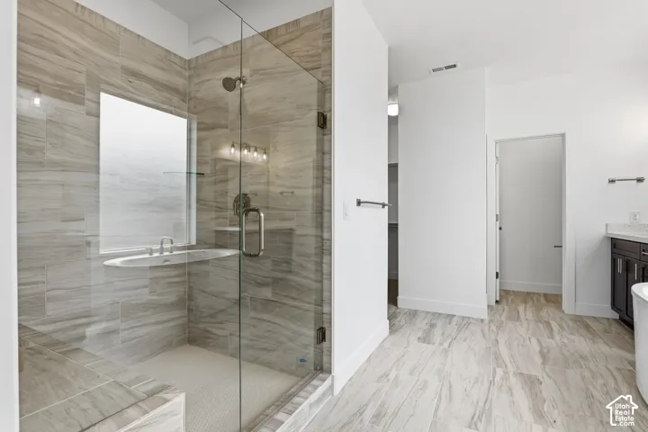 Glass-enclosed shower with a tiled surround, integrated shelf, and a built-in bench