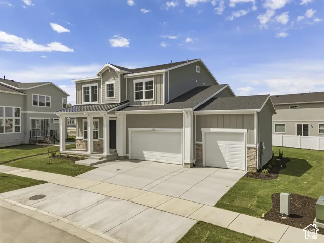 Two-story exterior with a covered porch, stone accents, and a dual garage