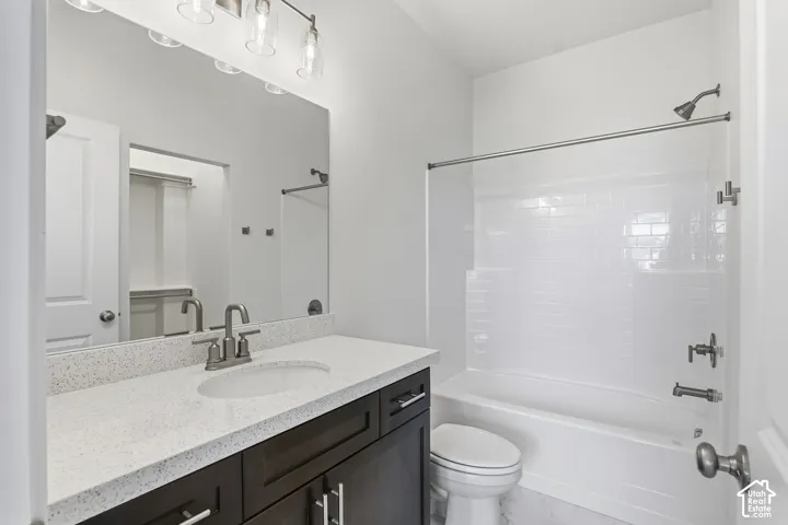 Contemporary bathroom featuring a dark wood-finish vanity with an integrated sink, a speckled light-toned countertop, and a sleek rectangular mirror