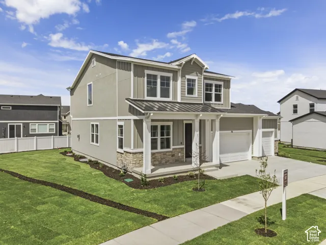 Two-story residence featuring a covered front porch, integrated two-car garage, and a concrete driveway