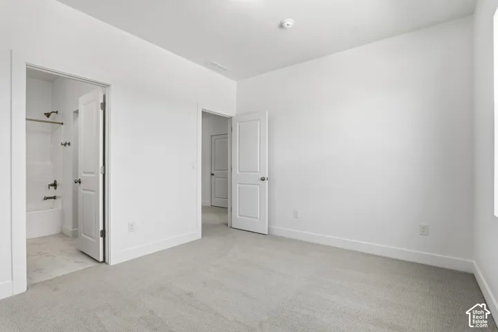 Light-colored carpeting, white walls, and white trim