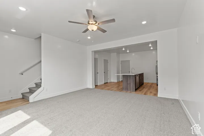 Open-concept living area with recessed lighting, ceiling fan, and carpeted flooring