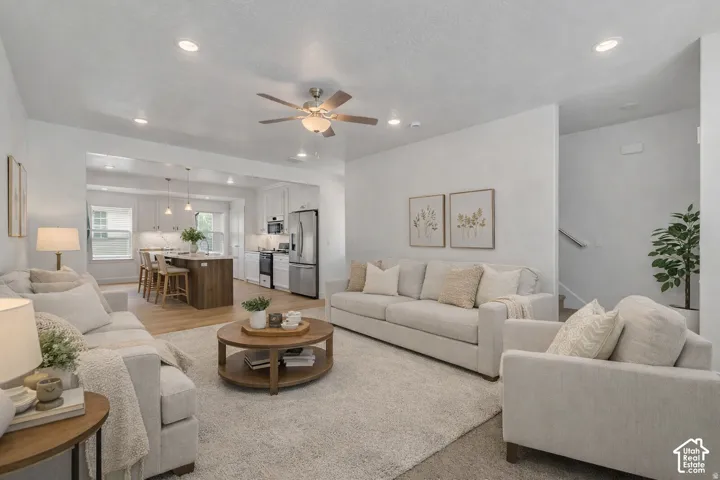 Recessed lighting throughout, wood-finish flooring, built-in kitchen island, stainless steel appliances, and a ceiling fan