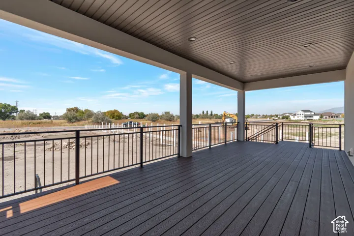Covered deck with composite flooring, recessed lighting, and black metal railings