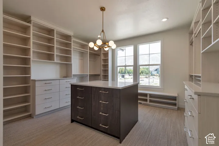 Custom built-in cabinetry, central island with storage, quartz countertops, multiple window light, and carpeted flooring