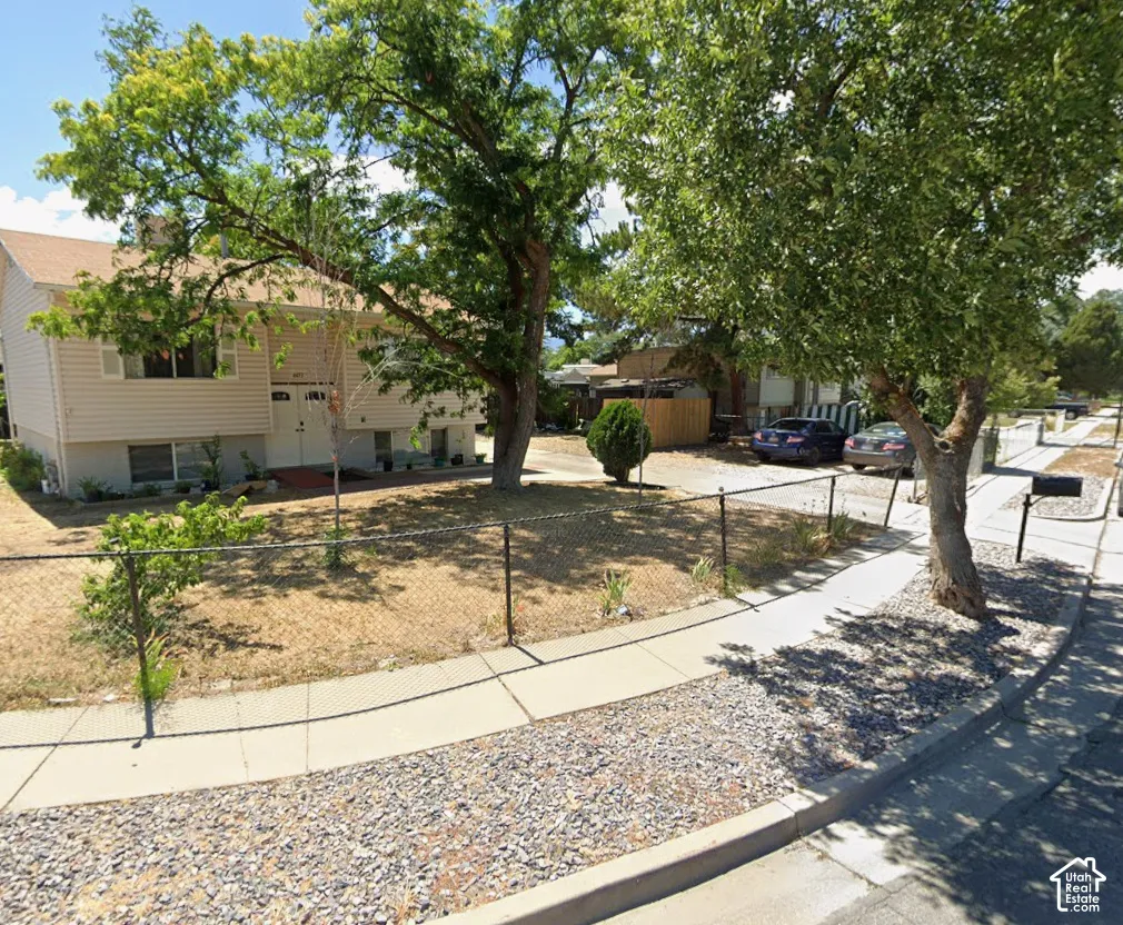 Two-story exterior with light-colored siding, multiple windows, and a prominent front entrance