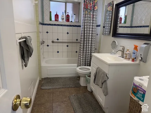 White tiled shower and tub combination with a grab bar