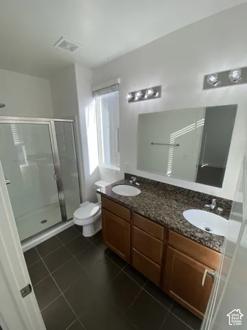 Dual vanity with integrated sinks, rich wood-finish cabinetry, and a patterned countertop