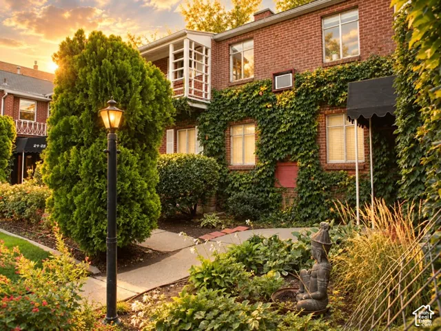 Brick exterior with extensive ivy coverage, a scalloped awning, and a traditional lamppost