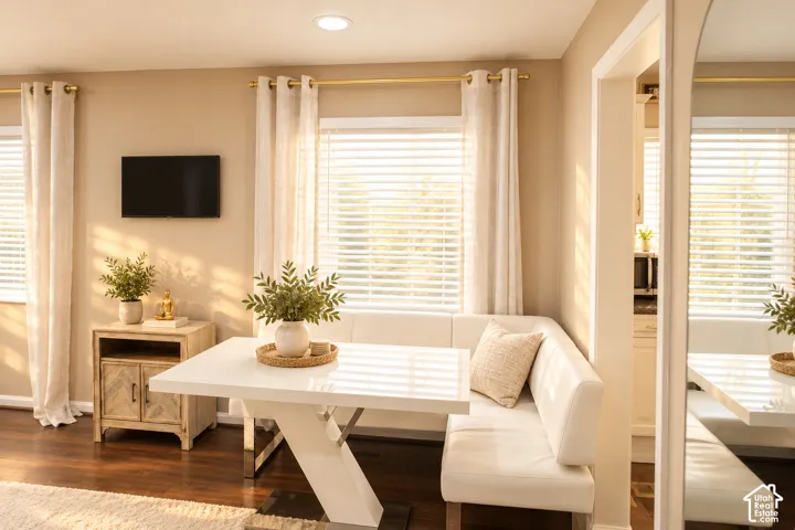 Recessed ceiling lighting, wood-finish flooring, white horizontal blinds, and a built-in banquette seating area