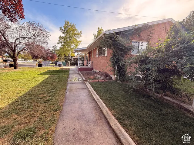 Brick exterior with mature landscaping and a concrete walkway