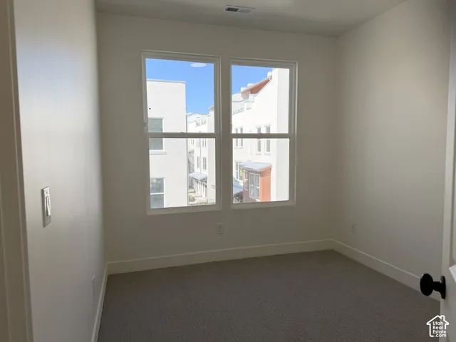 Neutral wall paint, dual pane windows, carpeting, white trim, and a contemporary black door handle