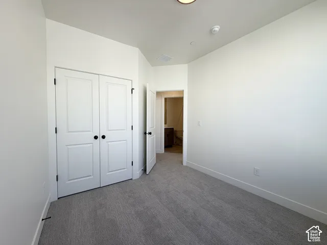 Neutral color palette, gray carpet, white walls, white trim, white doors with black hardware
