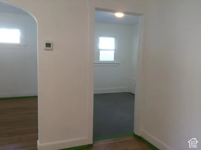 Hardwood-finish flooring, arched doorway, and built-in wall thermostat