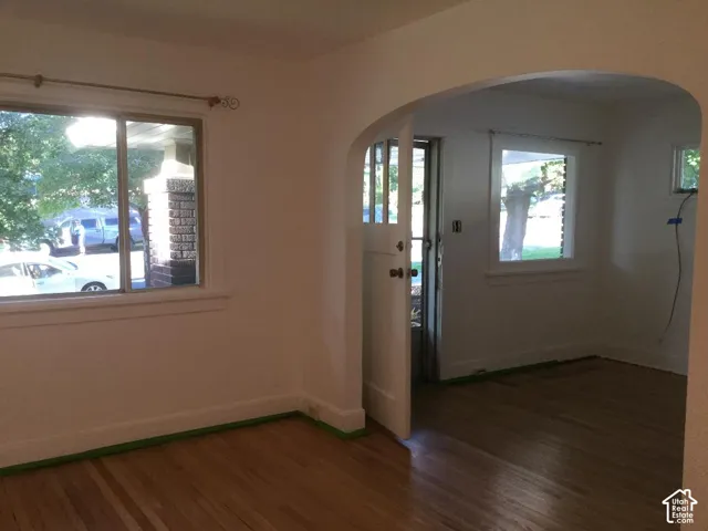 Bright interior spaces showcasing wood-finish flooring, large windows with natural light, and an arched architectural detail creating distinctive character