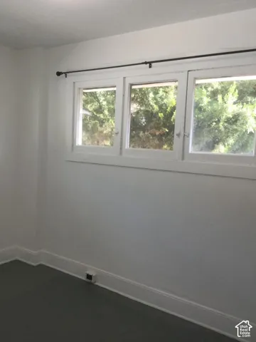Triple window unit with white trim and a black curtain rod