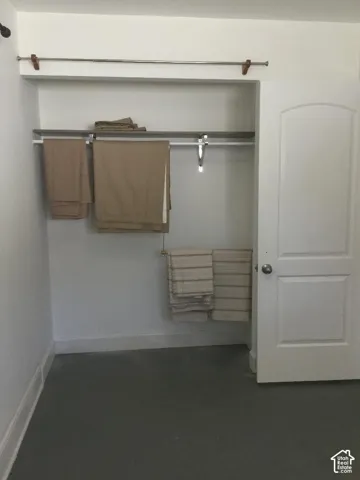 Built-in closet with dual hanging rods, upper shelving, and a paneled door