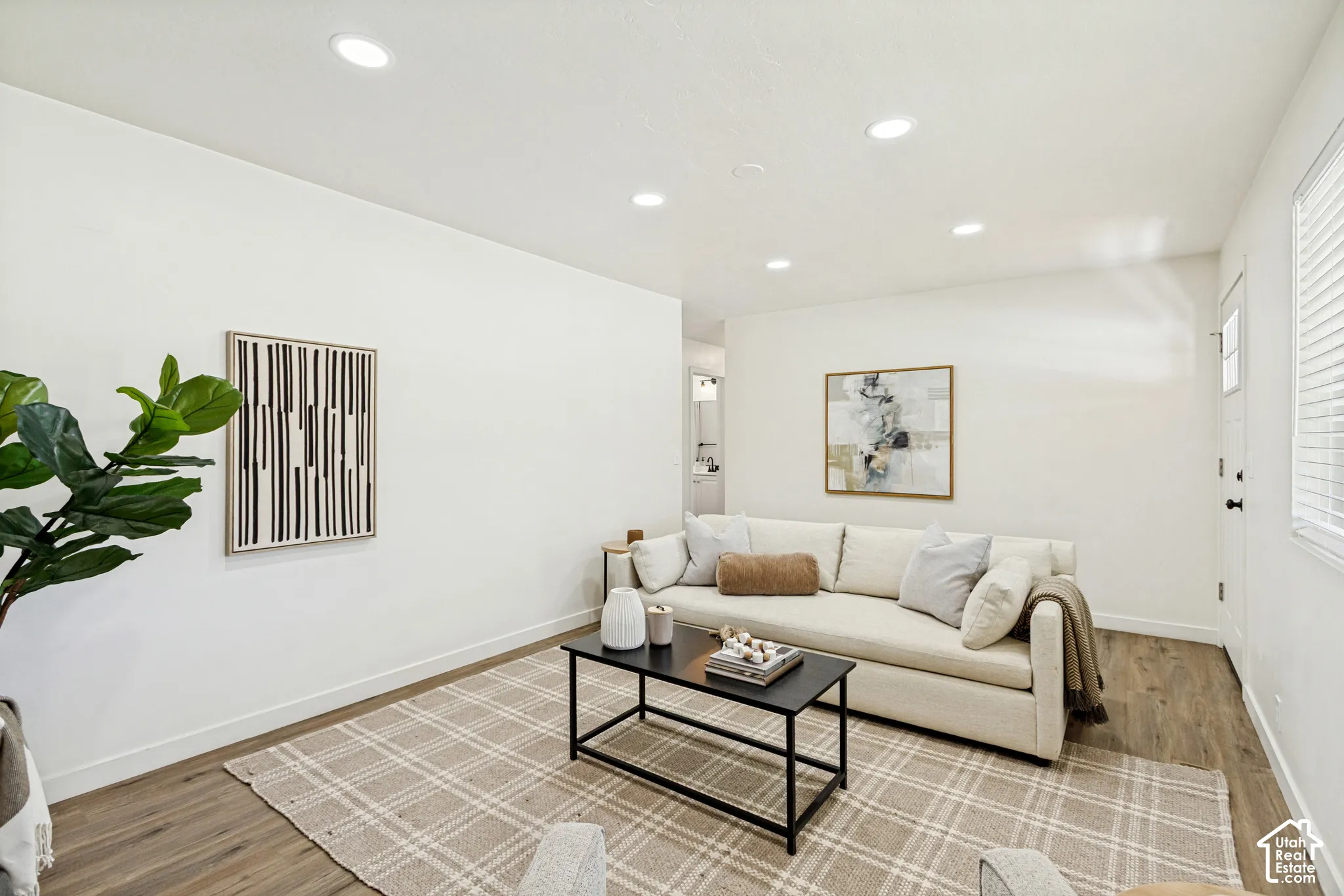Recessed ceiling lighting, durable wood-finish flooring, and white painted walls