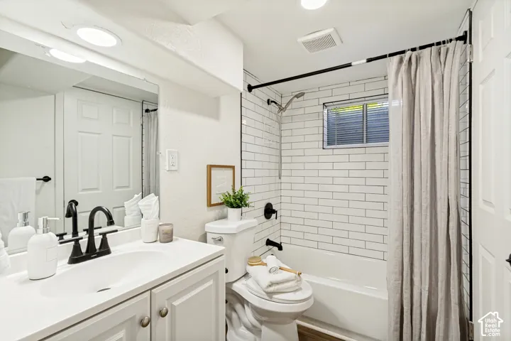 White vanity with a single basin, black faucet, and cabinet storage