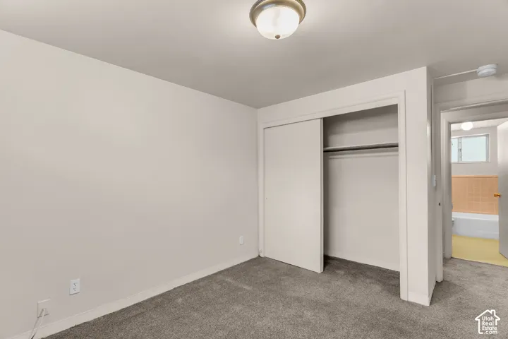 Carpeted flooring, recessed lighting, and a closet with sliding doors