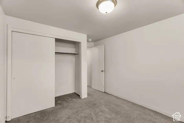 Recessed closet with sliding doors, neutral wall paint, and overhead flush-mount lighting