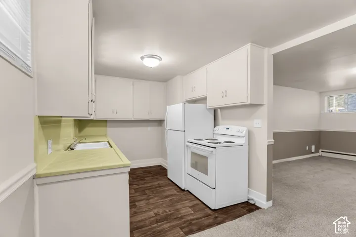 Efficient kitchen area featuring a full-size refrigerator, electric range, and ample cabinetry