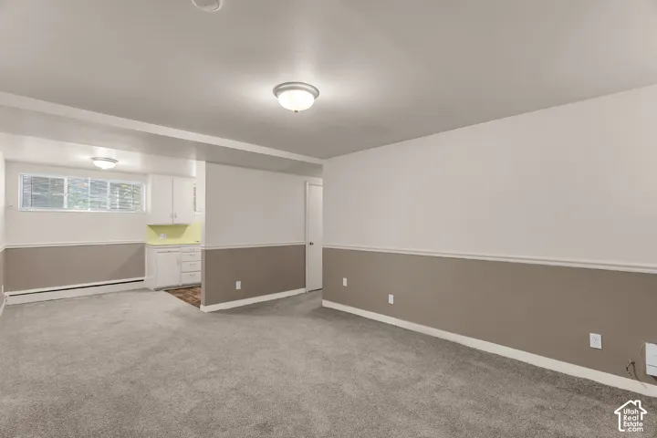 Carpeted flooring throughout, two-tone wall paint, built-in cabinetry, and window with blinds