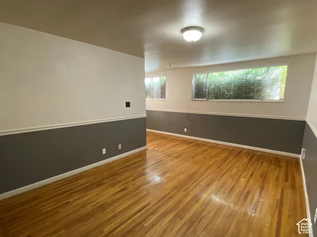 Wood-finish flooring, white and gray two-tone wall paint, white trim, and flush-mount lighting fixtures