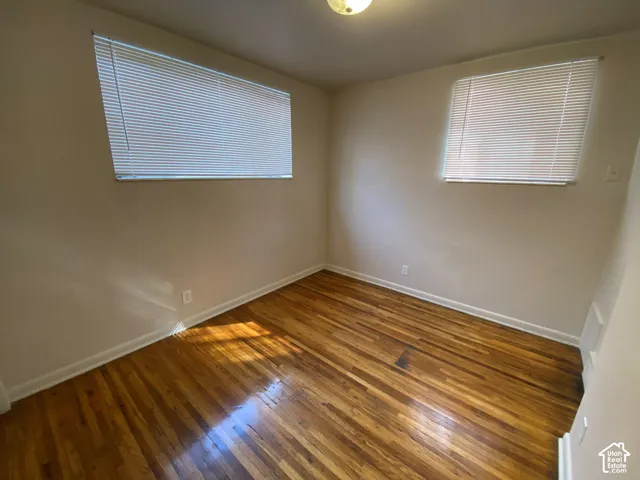 Wood-finish flooring, neutral wall tones, and overhead lighting