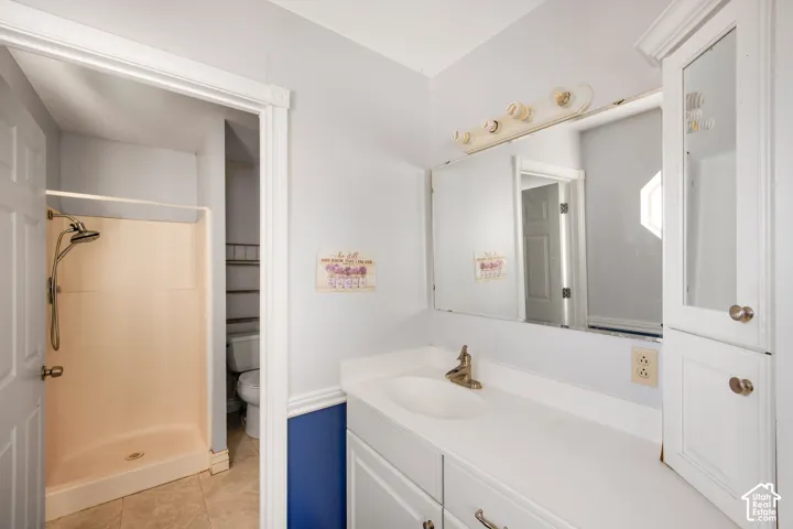 White vanity with integrated sink, brass-finish faucet, and a large mirror